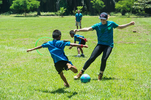 Teen volunteer playing with a child.