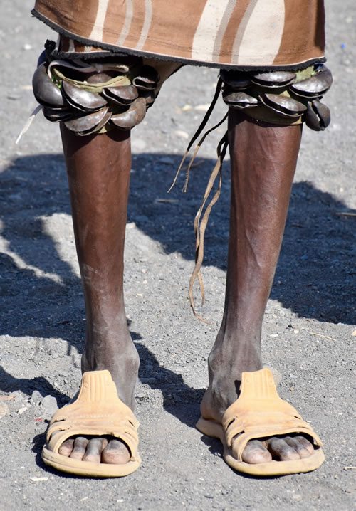 Turkana men perform dances with bells on knees in Kenya.