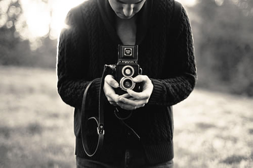 Woman taking a photography class abroad using an antique camera.