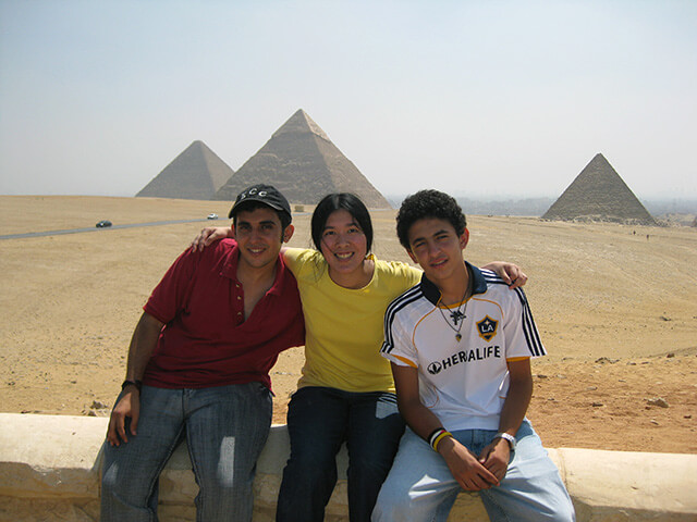 Studying Arabic in Egypt in high school with AFS, sitting between two other young male students, with the Pyramids of Giza in the background.