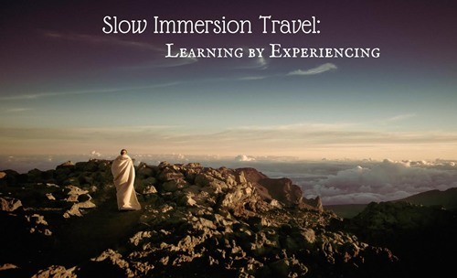 Slow immersion travel: learning by experiencing. A women looking from the top of mountain at the clouds in the distance.