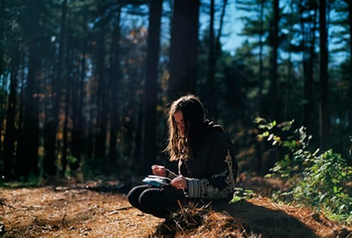 Teen reading in the woods.