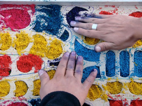 Finishing the symbolic Alfombras using fingers and dyes.