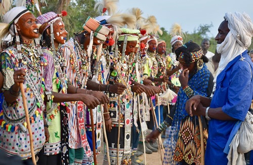 Girl accompanied by village elder in blue slowly approaching the lineup of dancers to make her choice for a mate.