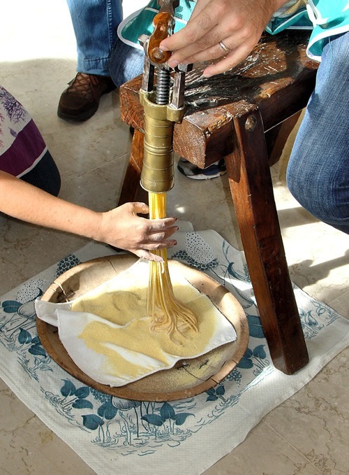 Bigoli emerges from pasta machine