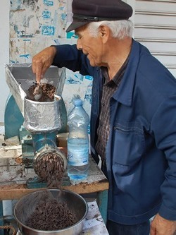 Grinding pine nuts.