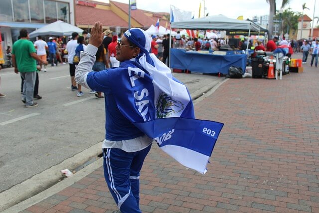 Man clapping in a market dressed in flag in El Salvador.