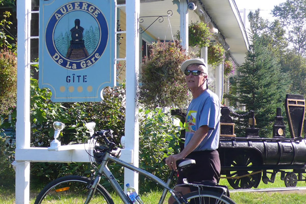 Man with cycle at the Auberge de la Gare.