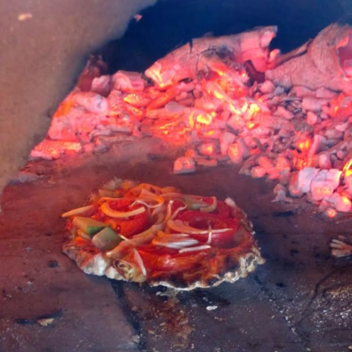 Farm jobs: Building a pizza oven where a pizza is baking.