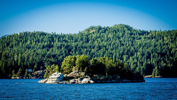 Vancouver Island house in the middle of a lake on a small green island.