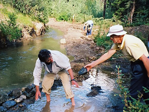 Senior volunteer vacation repairing an irrigation ditch with The Land Conservancy.