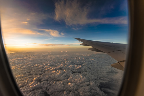 Air travel around the world with a spectacular window view of the sky above and clouds below, from the plane.