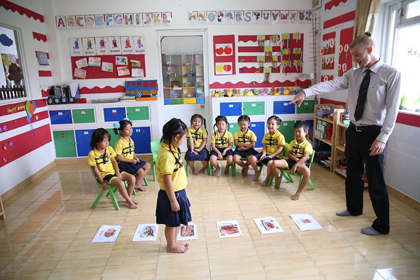 A kindergarten English teacher in a classroom with  small children.