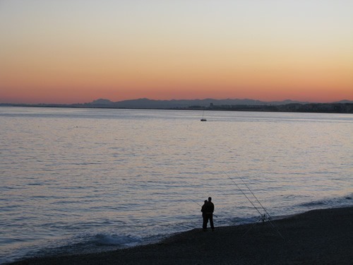 Fishermen at sunset on the beach of Nice.