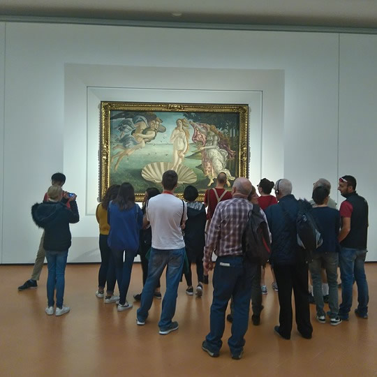 Group of students looking at a famous Sandro Botticell painting in Florence, Italy.