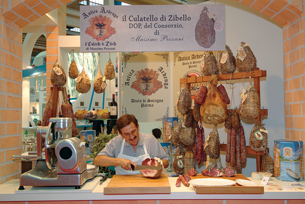 An Italian man cutting a piece of culatello (ham) as part of the Slow Food movement.