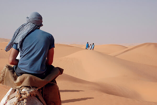 Author crossing the Sahara desert through the sand dunes.