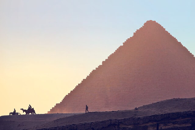 A typical scene with camels passing by the Giza Pyramid in Cairo, Egypt.